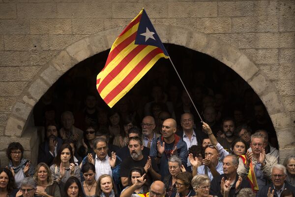 Catalan independence supporters, one waving an estelada, or Catalonia independence flag, applaud during a rally outside the city hall of Girona, Spain Catalan independence supporters, one waving an estelada, or Catalonia independence flag, applaud during a rally outside the city hall of Girona, Spain - Sputnik International