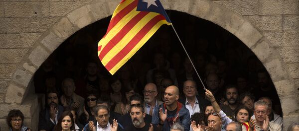 Catalan independence supporters, one waving an estelada, or Catalonia independence flag, applaud during a rally outside the city hall of Girona, Spain - Sputnik International