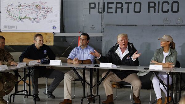 President Donald Trump and first lady Melania Trump participate in a briefing on hurricane recovery efforts with first responders at Luis Muniz Air National Guard Base, Tuesday, Oct. 3, 2017, in San Juan, Puerto Rico as Puerto Rico Gov. Ricardo Rosselló, left of the President, looks on. - Sputnik International