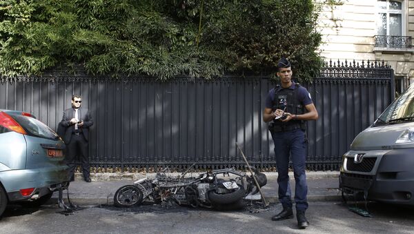 A police officer stands next to a burnt scooter outside the office of Jordan's military attache in Paris, Wednesday, Oct. 4, 2017 - Sputnik International