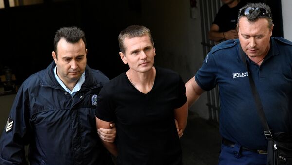 Alexander Vinnik, a 38 year old Russian man suspected of running a money laundering operation using bitcoin, is escorted by police officers while leaving a court in Thessaloniki, Greece, October 4, 2017 - Sputnik International