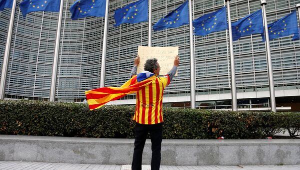Catalan Raimon Castellvi, wearing a flag with an Estelada (Catalan separatist flag), holds a sign as he protests outside the European Commission in Brussels after Sunday's independence referendum in Catalonia, Belgium October 2, 2017 - Sputnik International