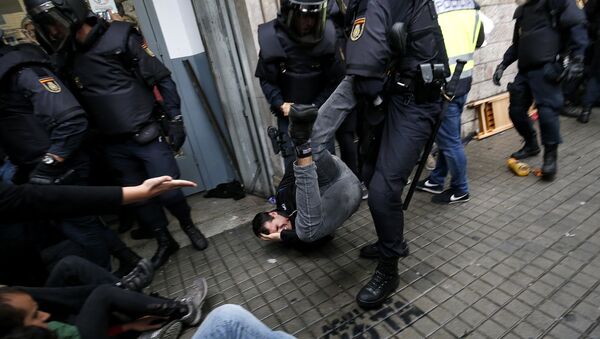 Spanish police officers drag a man as they try to disperse voters arriving to a polling station in Barcelona, on October 1, 2017 during a referendum on independence for Catalonia banned by Madrid - Sputnik International