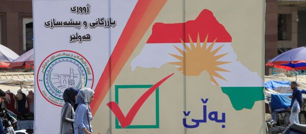 Iraqi women walk on the street, near banners supporting the referendum for independence for Kurdistan in Erbil, Iraq September 21, 2017 - Sputnik International