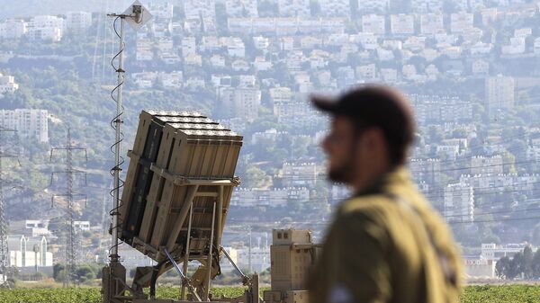 An Israeli soldier is seen next to an Iron Dome rocket interceptor battery deployed near the northern Israeli city of Haifa, Wednesday, Aug. 28, 2013.  - Sputnik International