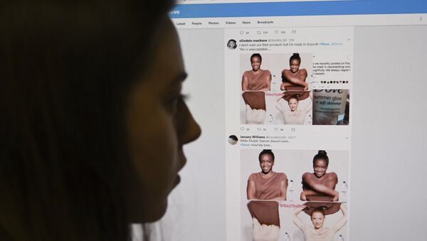 A posed picture taken in London on October 9, 2017 shows a journalist looking at screenshots retweeted by Twitter users on the social networking site of a video-clip used in an online advert by the personal care brand Dove that originally appeared on social networking website Facebook and has since been removed amid accusations of racism - Sputnik International