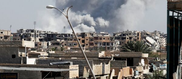 Smoke rises near the stadium where the Islamic State militants are holed up after an air strike by coalition forces at the frontline, in Raqqa, Syria October 12, 2017 - Sputnik International
