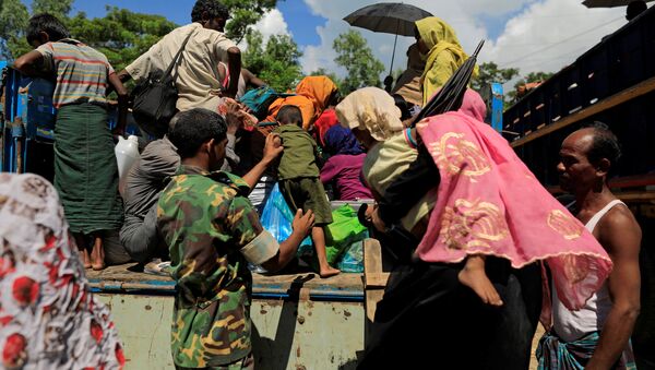A military member helps a Rohingya refugee boy who arrived from Myanmar to get onto a truck that will take him to a refugee camp from a relief centre in Teknaf, near Cox's Bazar in Bangladesh, October 13, 2017 - Sputnik International