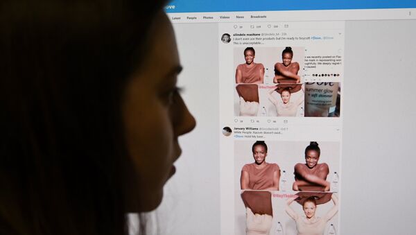 (FILES) This file photo taken on October 09, 2017 shows a posed photograph of a journalist looking at screenshots retweeted by Twitter users on the social networking site of a video-clip used in an online advert by the personal care brand Dove - Sputnik International