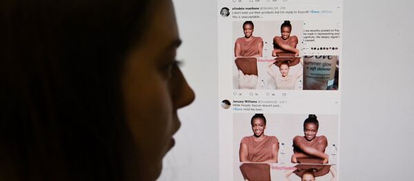 (FILES) This file photo taken on October 09, 2017 shows a posed photograph of a journalist looking at screenshots retweeted by Twitter users on the social networking site of a video-clip used in an online advert by the personal care brand Dove - Sputnik International