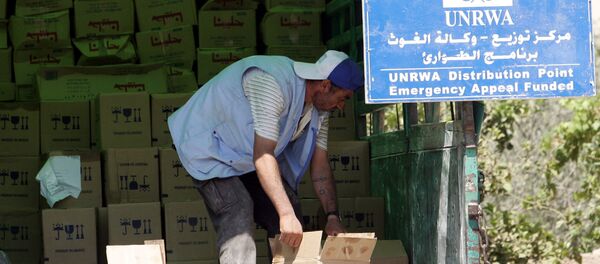 A Palestinian worker unloads boxes as provisions are by the United Nations Relief and Works Agency for Palestine Refugees in the Near East (UNRWA). (File) - Sputnik International