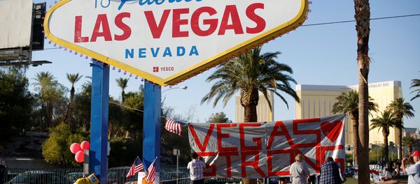 People sign a banner near the Welcome to Fabulous Las Vegas sign following the Route 91 music festival mass shooting in Las Vegas, Nevada, U.S., October 5, 2017 - Sputnik International