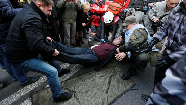 An injured man receives help during a rally by supporters of former Georgian President Mikheil Saakashvili and different political parties demanding an electoral reform, in front of Ukrainian parliament in Kiev, Ukraine October 17, 2017 - Sputnik International