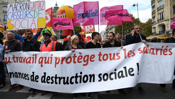 People hold a banner reading a work which protects all the employees during a demonstration called by the CGT workers' union against the French president's labour law reforms, on October 19, 2017 in Paris - Sputnik International