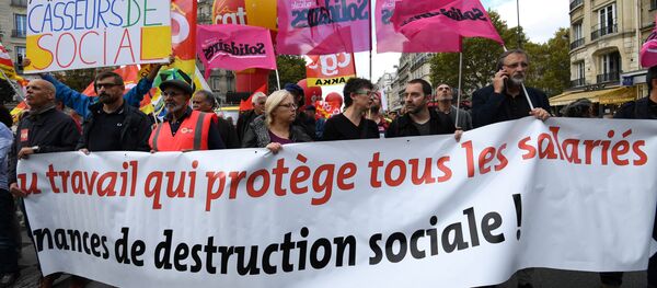People hold a banner reading a work which protects all the employees during a demonstration called by the CGT workers' union against the French president's labour law reforms, on October 19, 2017 in Paris People hold a banner reading a work which protects all the employees during a demonstration called by the CGT workers' union against the French president's labour law reforms, on October 19, 2017 in Paris - Sputnik International