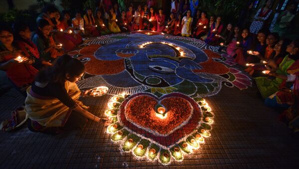 Students pose after lighting oil lamps around a Rangoli, a traditional pattern made from coloured powders and flower petals outside their hostel to celebrate Diwali, the Hindu festival of lights, in Guwahati, India, October 19, 2017 - Sputnik International