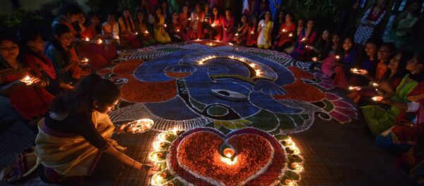 Students pose after lighting oil lamps around a Rangoli, a traditional pattern made from coloured powders and flower petals outside their hostel to celebrate Diwali, the Hindu festival of lights, in Guwahati, India, October 19, 2017 - Sputnik International