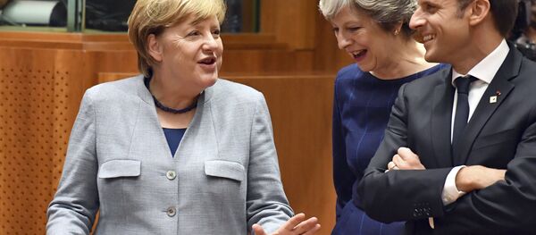 German Chancellor Angela Merkel, left, speaks with British Prime Minister Theresa May, center, and French President Emmanuel Macron prior to a round table meeting at an EU summit in Brussels on Thursday, Oct. 19, 2017. - Sputnik International
