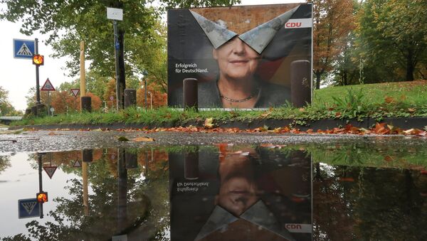 An election campaign poster of Angela Merkel, German Chancellor and leader of the Christian Democratic Union party CDU is reflected in a puddle one week following Germany's general election in Bonn, September 30, 2017 - Sputnik International