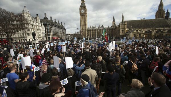 People gather in Parliament Square as part of a national day of action in support of migrants in the UK, in London with the Houses of Parliament back right, Monday Feb. 20, 2017. British lawmakers are set to hold a debate on Monday in London to consider a call for U.S. President Donald Trump to be denied an official state visit to the U.K., but the Conservative government insists the invitation remains firmly in place. - Sputnik International