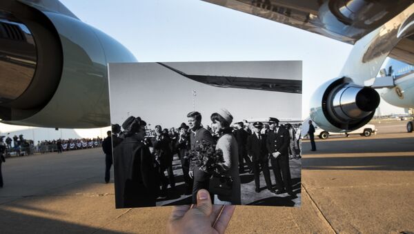 This file photo taken on November 8, 2013 shows a historic photo dated November 22, 1963 showing former US President John F. Kennedy and First Lady Jacqueline Kennedy arriving in Dallas, Texas (Cecil Stoughton, White House Photographs, John F. Kennedy Presidential Library and Museum, Boston) being held up by the photographer against Air Force One in the background as former US President Barack Obama arrives at Love Field in Dallas, Texas - Sputnik International