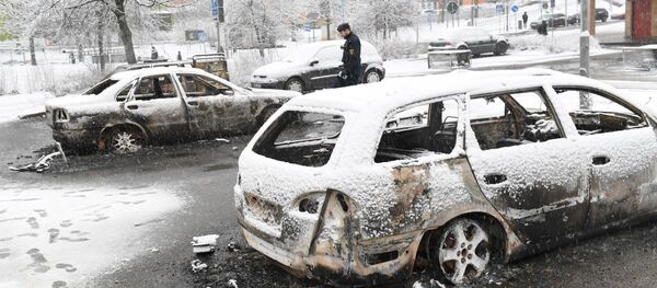 A policeman investigates a burned out car in the suburb Rinkeby, outside Stockholm, on February 21, 2017. Several cars was set in to fire after a riot in Rinkeby. The turmoil started when the police was going to arrest a man in the area A policeman investigates a burned out car in the suburb Rinkeby, outside Stockholm, on February 21, 2017. Several cars was set in to fire after a riot in Rinkeby. The turmoil started when the police was going to arrest a man in the area - Sputnik International