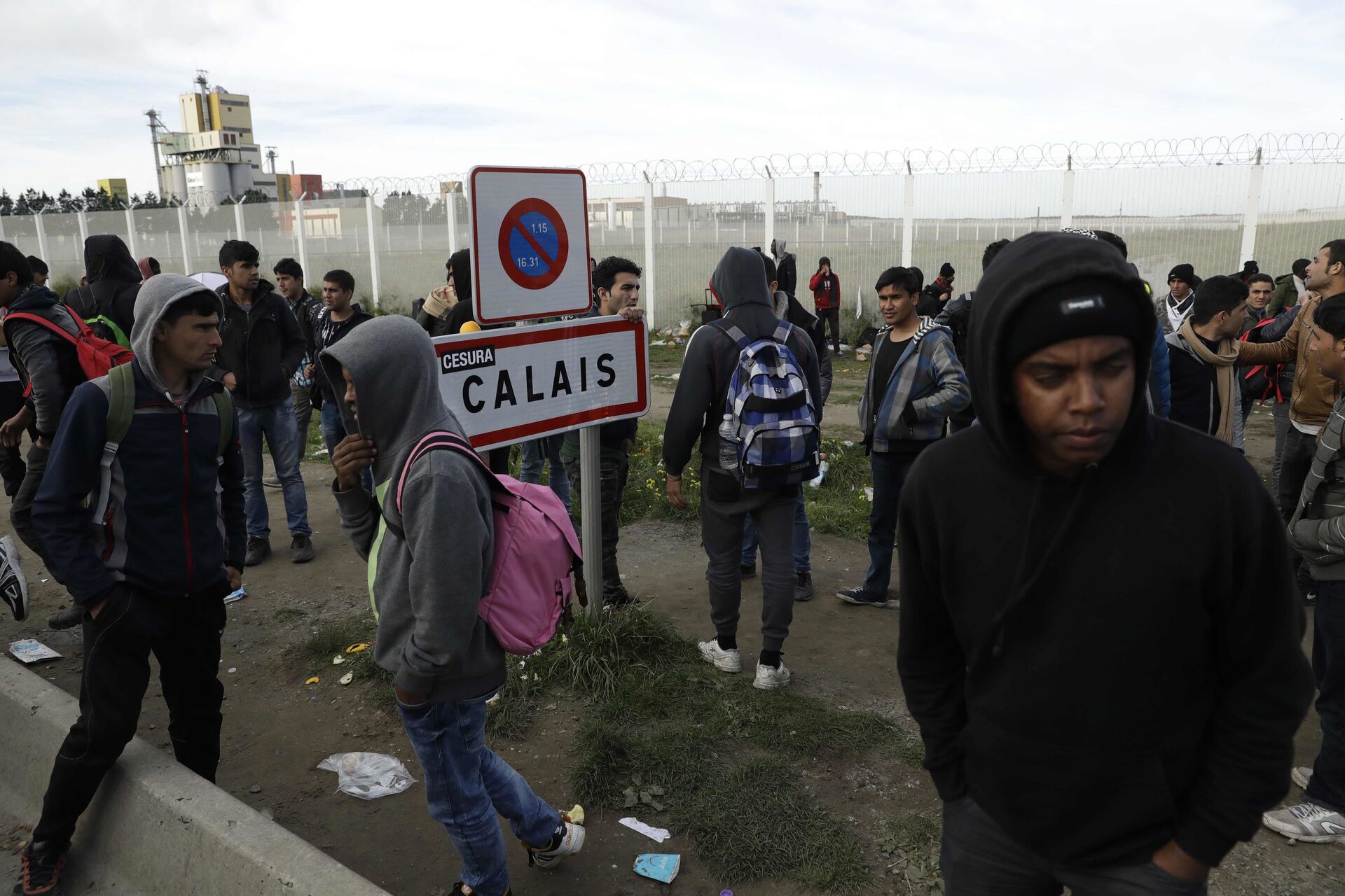 In this Thursday, Oct. 27, 2016 file photo migrants gather near a fence in Calais, northern France.  - Sputnik International, 1920, 15.11.2021