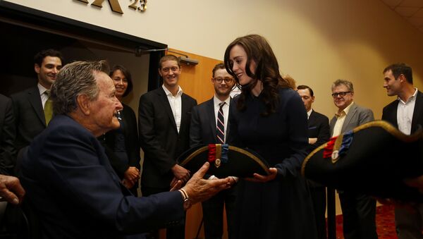 Former President George H.W. Bush, left, receives a tri-corner hat from actress Heather Lind, right, at a private screening of AMC's new series TURN in Houston, Texas. (File) - Sputnik International