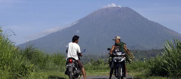 Villagers on their motorcycles talk each other with Mount Agung volcano in the background in Karangasem, Bali, Indonesia, Wednesday, Oct. 25, 2017 - Sputnik International