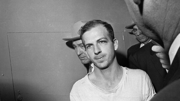In this Nov. 23, 1963 file photo, Lee Harvey Oswald is led down a corridor of the Dallas police station for another round of questioning in connection with the assassination of US, President John F. Kennedy. Oswald, who denied any involvement in the shooting, was formally charged with murder. - Sputnik International