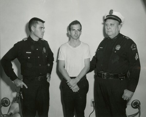 Lee Harvey Oswald, accused of assassinating former U.S. President John F. Kennedy, is pictured with Dallas police Sgt. Warren (R) and a fellow officer in Dallas, in this handout image taken on November 22, 1963. Lee Harvey Oswald, accused of assassinating former U.S. President John F. Kennedy, is pictured with Dallas police Sgt. Warren (R) and a fellow officer in Dallas, in this handout image taken on November 22, 1963. - Sputnik International
