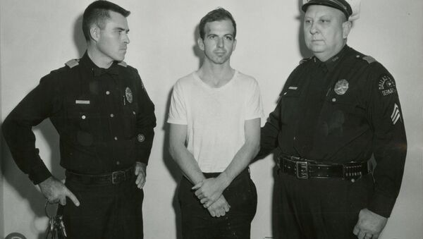 Lee Harvey Oswald, accused of assassinating former U.S. President John F. Kennedy, is pictured with Dallas police Sgt. Warren (R) and a fellow officer in Dallas, in this handout image taken on November 22, 1963. - Sputnik International