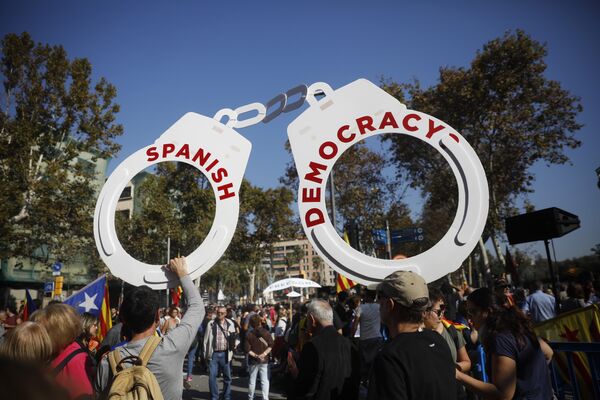 Protesters hold fake handcuffs as they take part a rally outside the Catalan parliament in Barcelona, Spain, Friday, Oct. 27, 2017. Protesters hold fake handcuffs as they take part a rally outside the Catalan parliament in Barcelona, Spain, Friday, Oct. 27, 2017. - Sputnik International