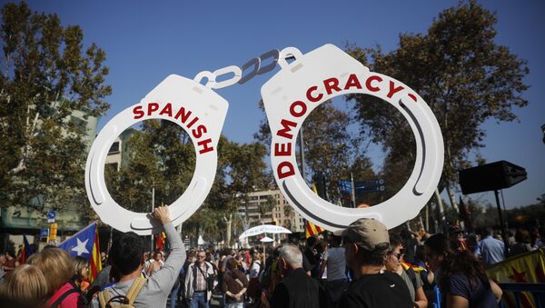 Protesters hold fake handcuffs as they take part a rally outside the Catalan parliament in Barcelona, Spain, Friday, Oct. 27, 2017. - Sputnik International