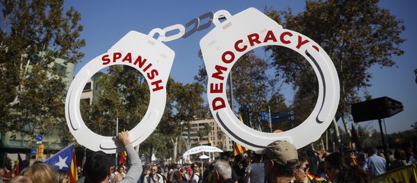 Protesters hold fake handcuffs as they take part a rally outside the Catalan parliament in Barcelona, Spain, Friday, Oct. 27, 2017. - Sputnik International