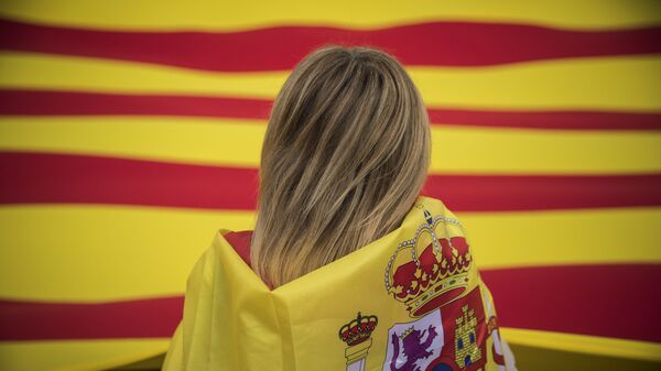 A woman wearing a Spanish flag on her shoulders looks at a giant flag of Catalonia as people celebrate a holiday known as Dia de la Hispanidad or Spain's National Day in Barcelona, Spain, Thursday, Oct. 12, 2017.  - Sputnik International