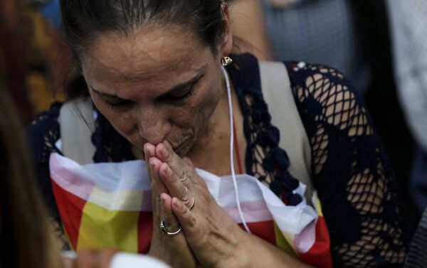 A woman prays outside the Catalan parliament in Barcelona on October 27, 2017, during a plenary session to vote on a motion on declaring independence from Spain - Sputnik International
