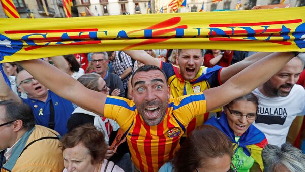 A man displays a scarf featuring an Estelada (Catalan separatist flag) design, as he reacts at Sant Jaume Square after the Catalan regional parliament declares independence from Spain in Barcelona, Spain October 27, 2017. - Sputnik International