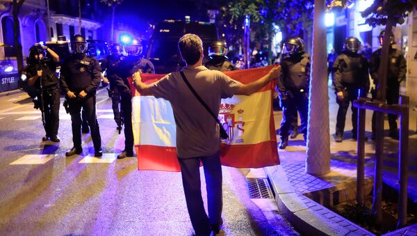 A pro unity demonstrator displays a Spanish flag to Catalan Regional Police officers during a protest after the Catalan regional parliament declared independence from Spain in Barcelona, Spain, October 27, 2017 - Sputnik International