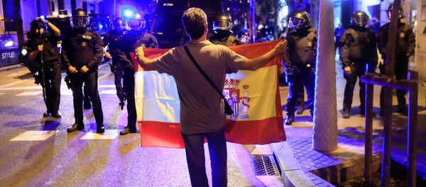 A pro unity demonstrator displays a Spanish flag to Catalan Regional Police officers during a protest after the Catalan regional parliament declared independence from Spain in Barcelona, Spain, October 27, 2017 - Sputnik International