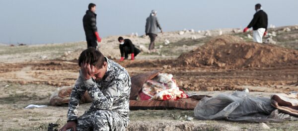 An Iraqi policeman collects himself at the burial site for bodies found in a mass grave containing some two dozen people, many of them children, in an area recently re-taken from Islamic State militants in Hamam al-Alil, Iraq, Wednesday, March 15, 2017 An Iraqi policeman collects himself at the burial site for bodies found in a mass grave containing some two dozen people, many of them children, in an area recently re-taken from Islamic State militants in Hamam al-Alil, Iraq, Wednesday, March 15, 2017 - Sputnik International