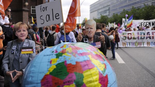 Protesters wear masks of German Chancellor Angela Merkel and US President Donald Trump as they take part in the solidarity without borders instead of G20 demonstration on July 8, 2017 in Hamburg, northern Germany as world leaders meet during the G20 summit - Sputnik International