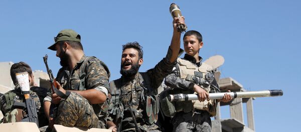 Fighters of Syrian Democratic Forces jubilate aboard an armoured fighting vehicle after Raqqa was liberated from the Islamic State militants, in Raqqa, Syria October 17, 2017 - Sputnik International