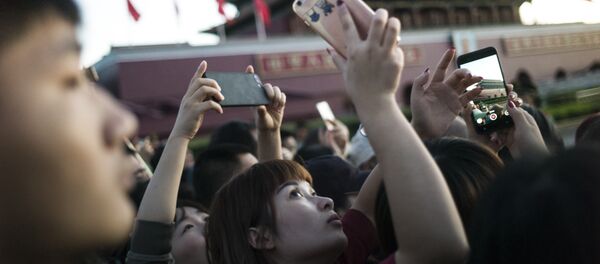 A Chinese lady takes pictures with her phone of the paramilitary guards on Tiananmen square during the rising flag in Beijing on September 20, 2017 A Chinese lady takes pictures with her phone of the paramilitary guards on Tiananmen square during the rising flag in Beijing on September 20, 2017 - Sputnik International
