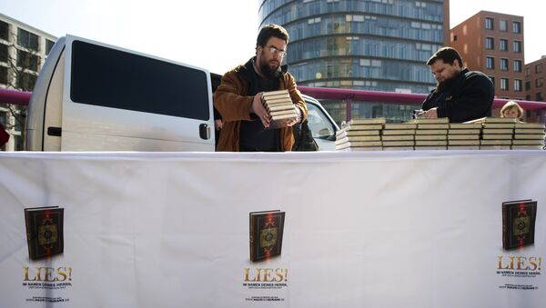 Supporters of the Salafist group House of the Quran (Haus vom Karan) give out Korans at Potsdamer Plarz in Berlin on April 14, 2012. The banner reads: Read! in the name of your Lord - Sputnik International