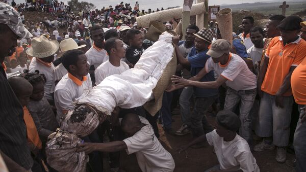 People carry a body wrapped in a sheet as they take part in a funerary tradition called the Famadihana in the village of Ambohijafy, a few kilometres from Antananarivo, on September 23, 2017 - Sputnik International