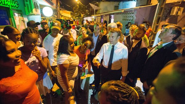 French President Emmanuel Macron (C,R) speaks with residents during a visit to the Crique neighborhood, in Cayenne, on October 27, 2017 as part of a three-day visit in French Guiana - Sputnik International