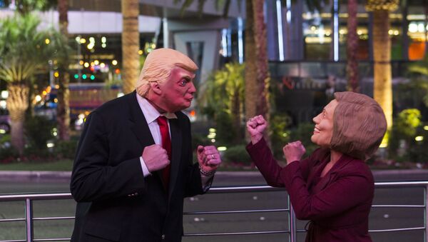 Donald Trump impersonator Rafael Almodovar, left, and Hillary Clinton impersonator Corina Almodovar entertain a crowd as early election results come in from a television display above, Tuesday, Nov. 8, 2016, during election night in Las Vegas - Sputnik International