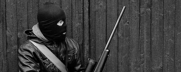 A man wearing a balaclava and holding a weapon - Sputnik International
