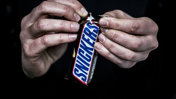 A man opens a Snickers chocolate bar on February 23, 2016 in Lyon, central eastern France - Sputnik International